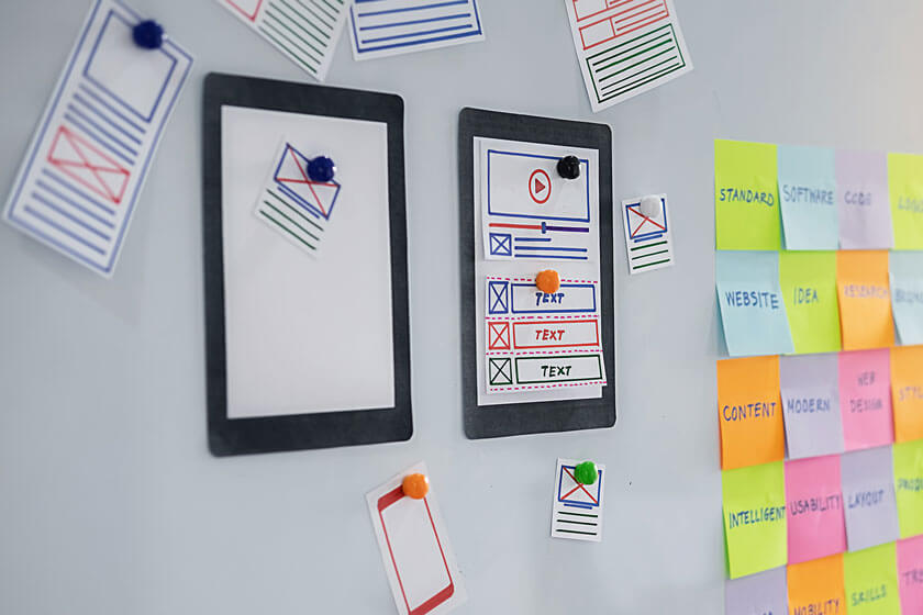User Experience Workshop concept - post it notes and wireframe ideas on a board